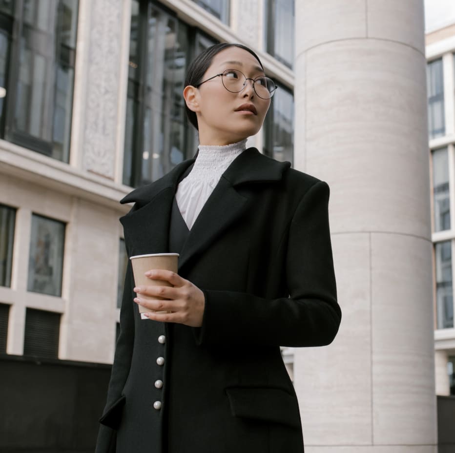 Businesswoman walking confidently while holding a cup of coffee